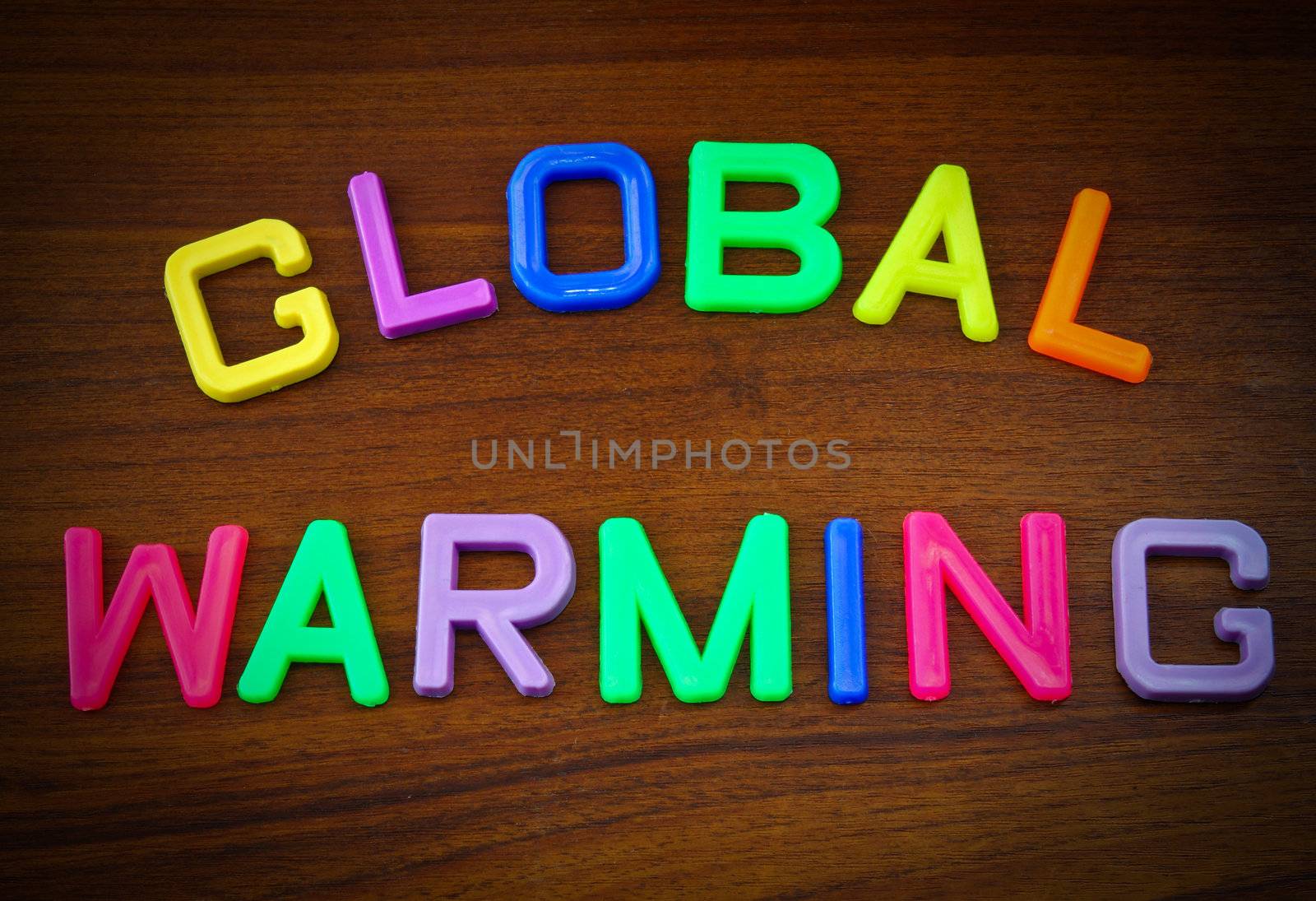 Global warming in colorful toy letters on wood background