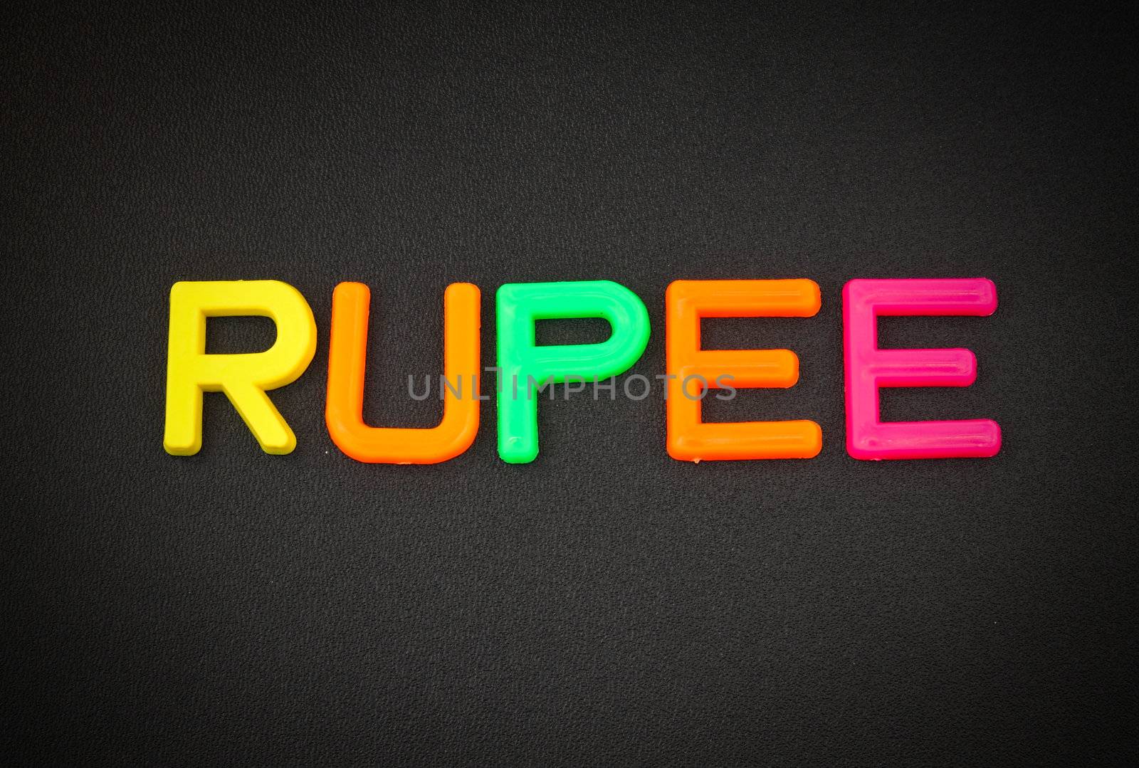 Rupee in colorful toy letters on black background