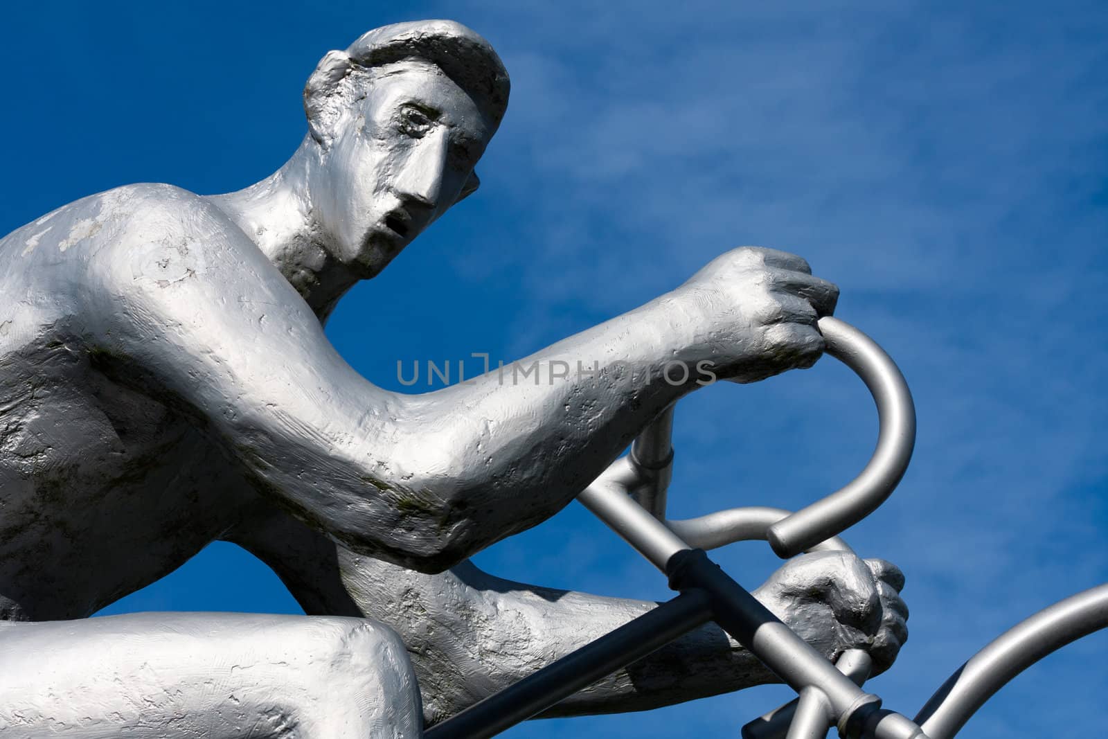 Sculpture of a cyclist in the early twentieth century, climbing a col