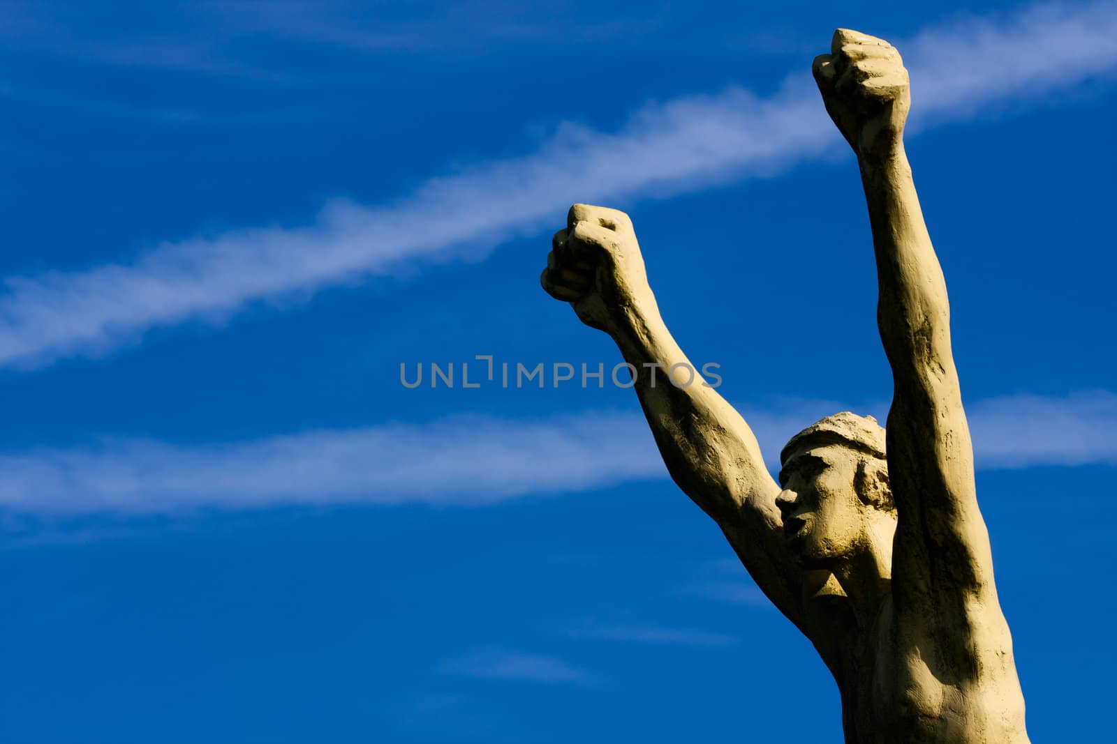 Sculpted bust of the winner, arms raised in v, fists clenched