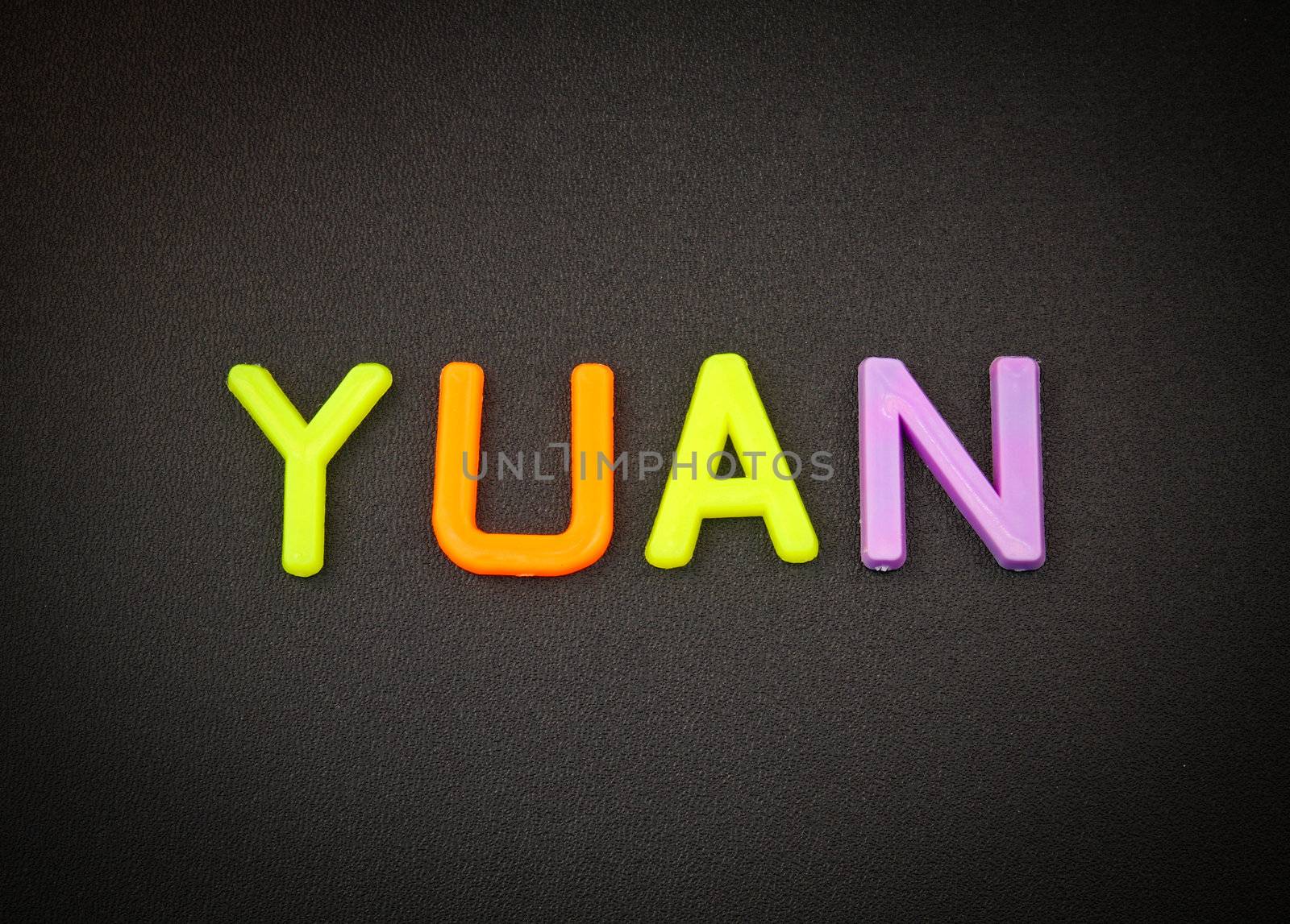 Yuan in colorful toy letters on black background by nuchylee