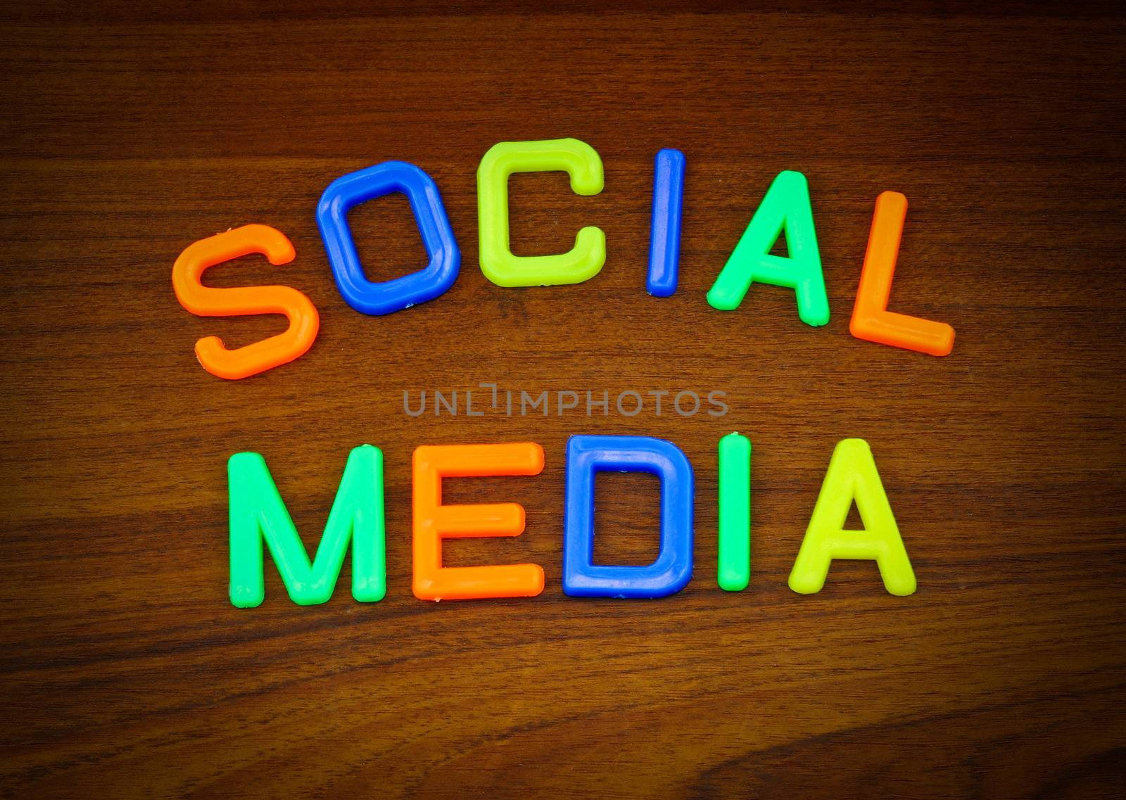Social media in colorful toy letters on wood background