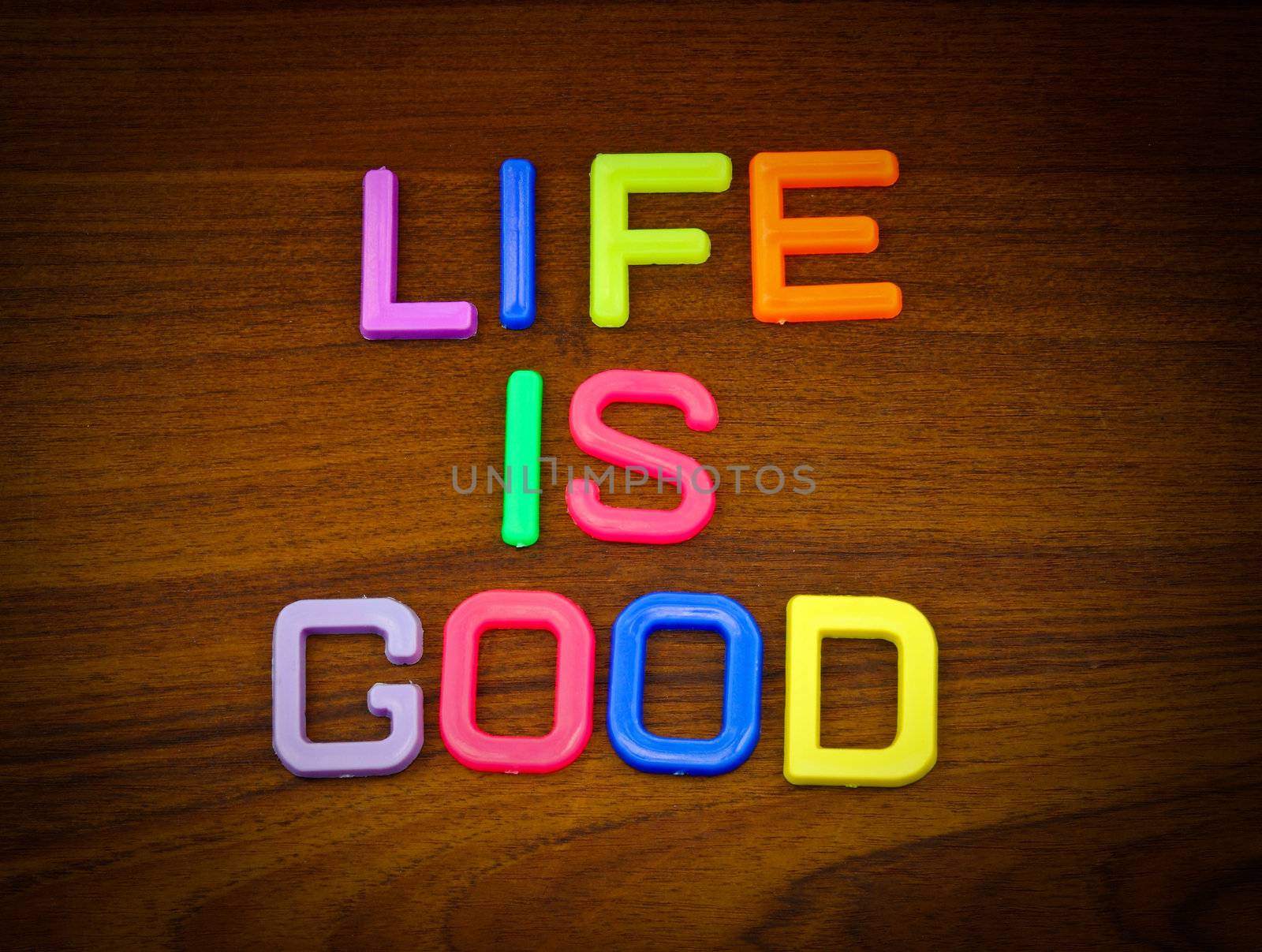 Life is good in colorful toy letters on wood background  by nuchylee