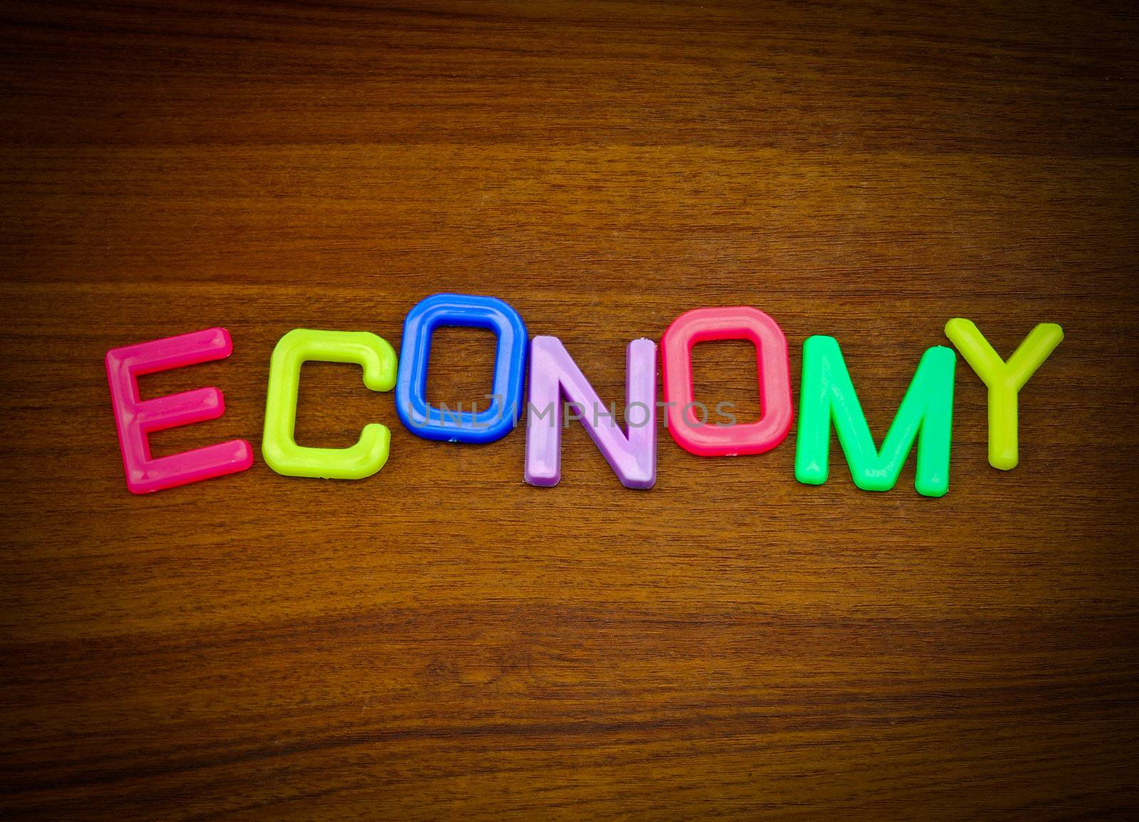 Economy in colorful toy letters on wood background