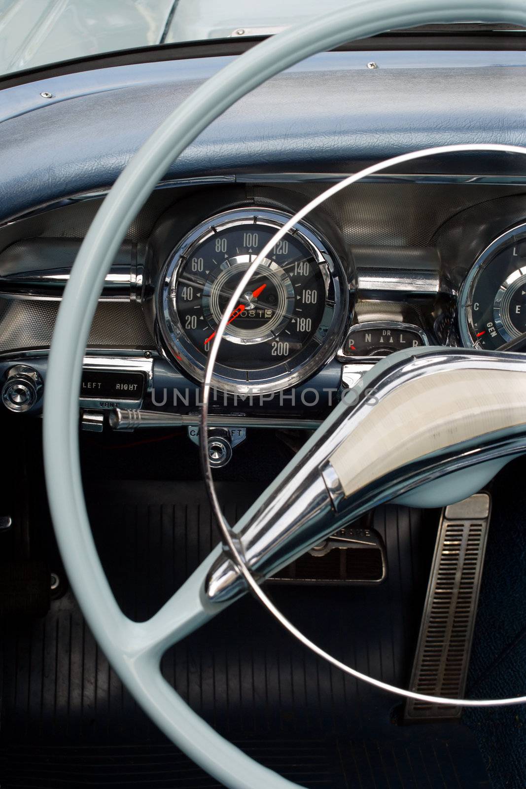 The steering wheel and dashboard of an antique classic car.
