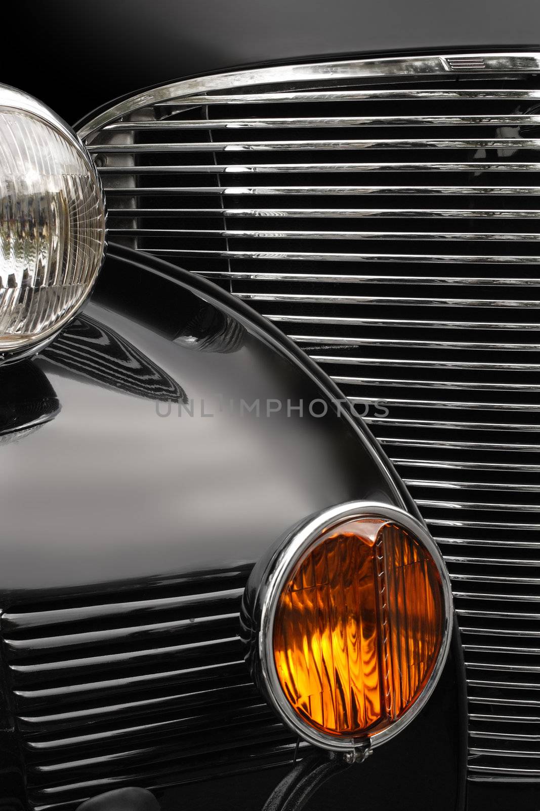 The chrome grill and headlights of an antique classic car.