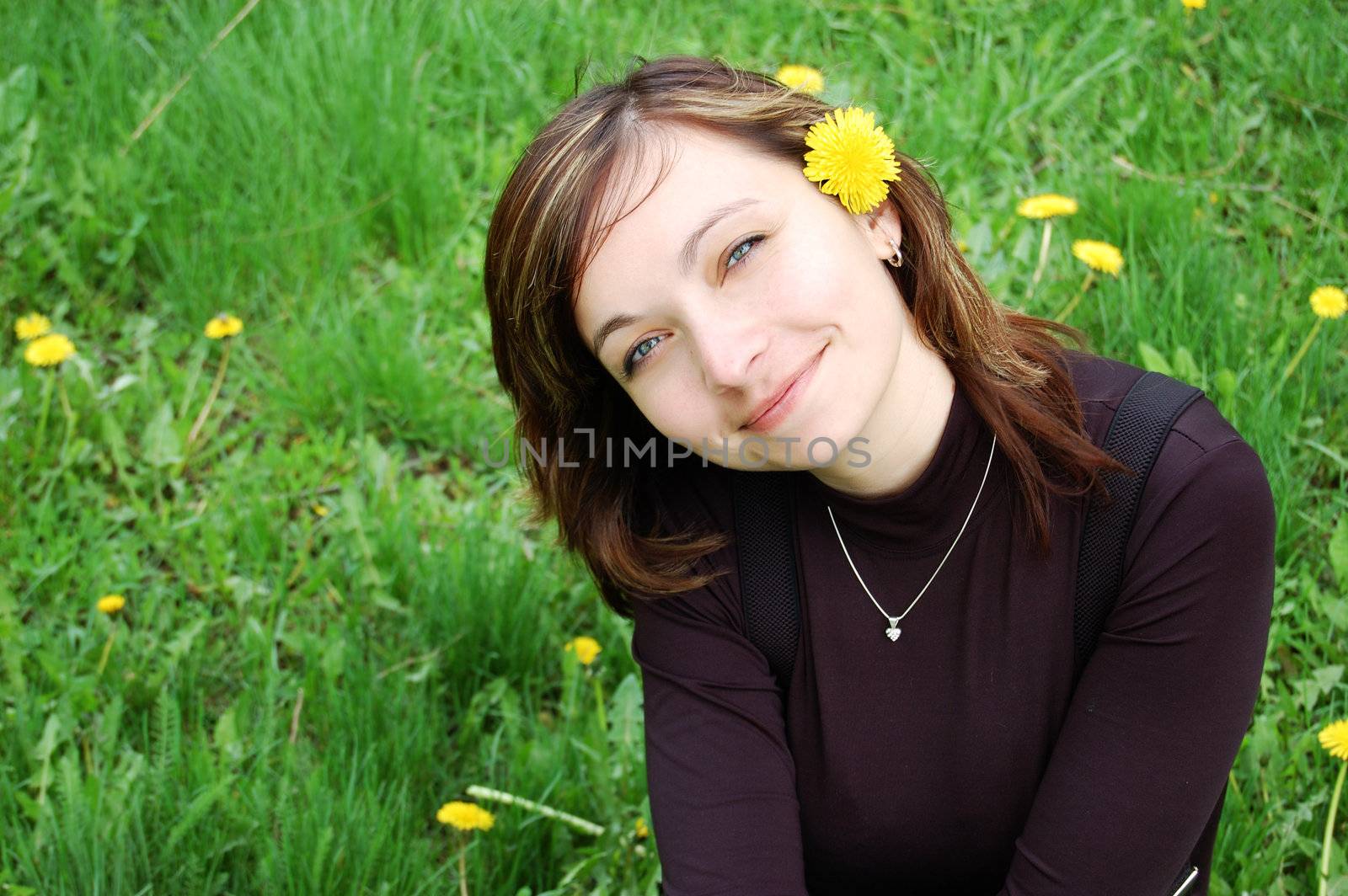 Girl with dandelion over green grass