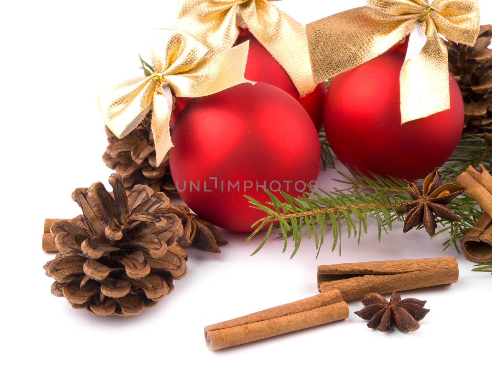 Red glass balls with nice golden ribbons, cinnamon and fresh spruce on white background