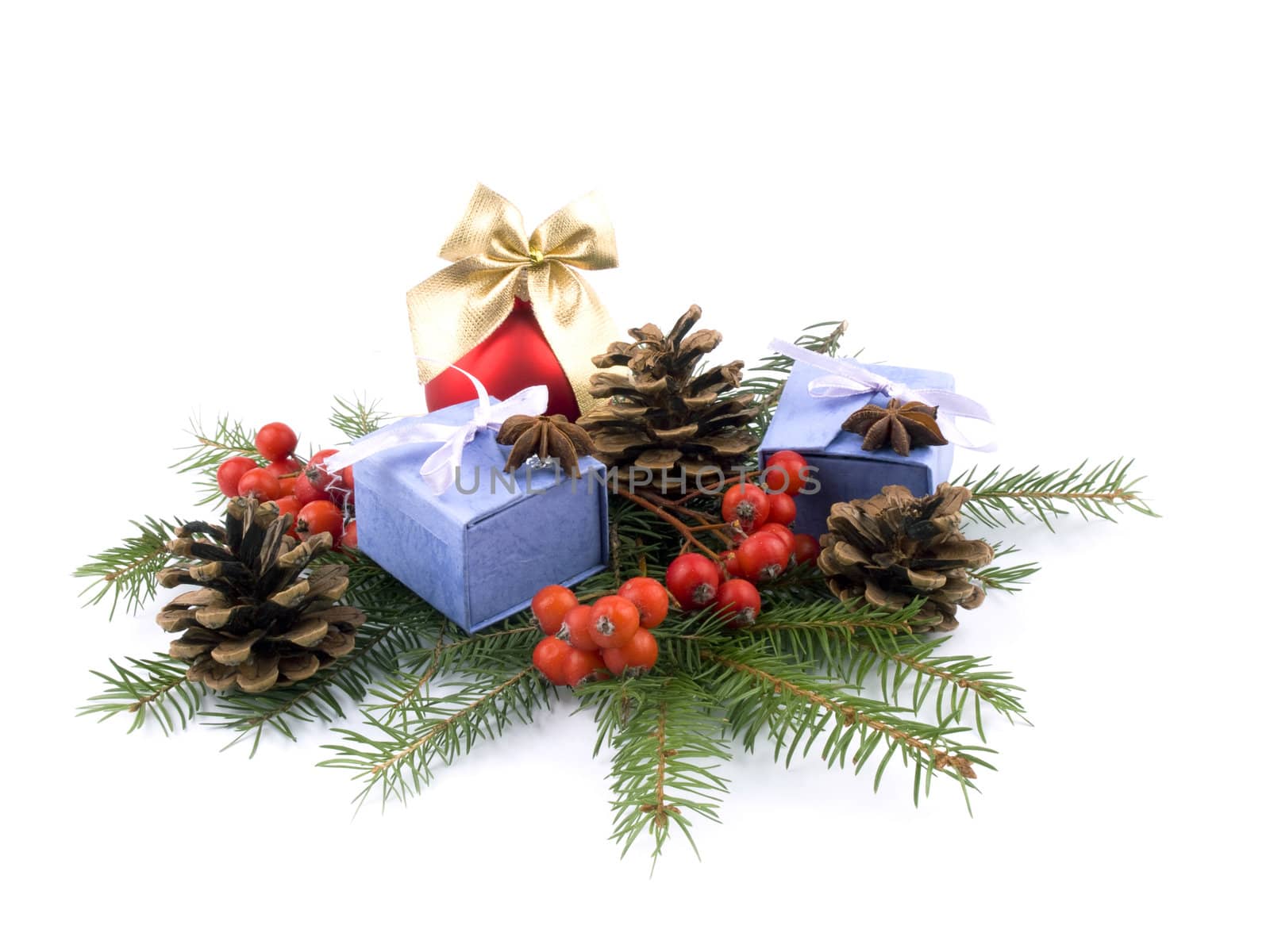 Christmas composition made from red glass ball, rowan, spruce, lilac giftboxes and cones on white background