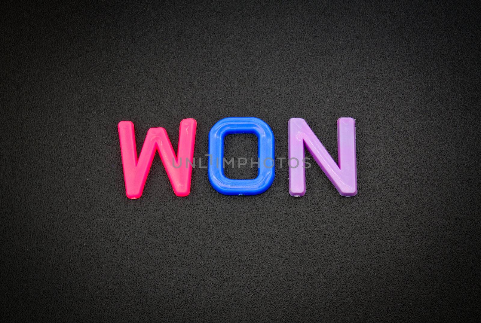 Won in colorful toy letters on black background