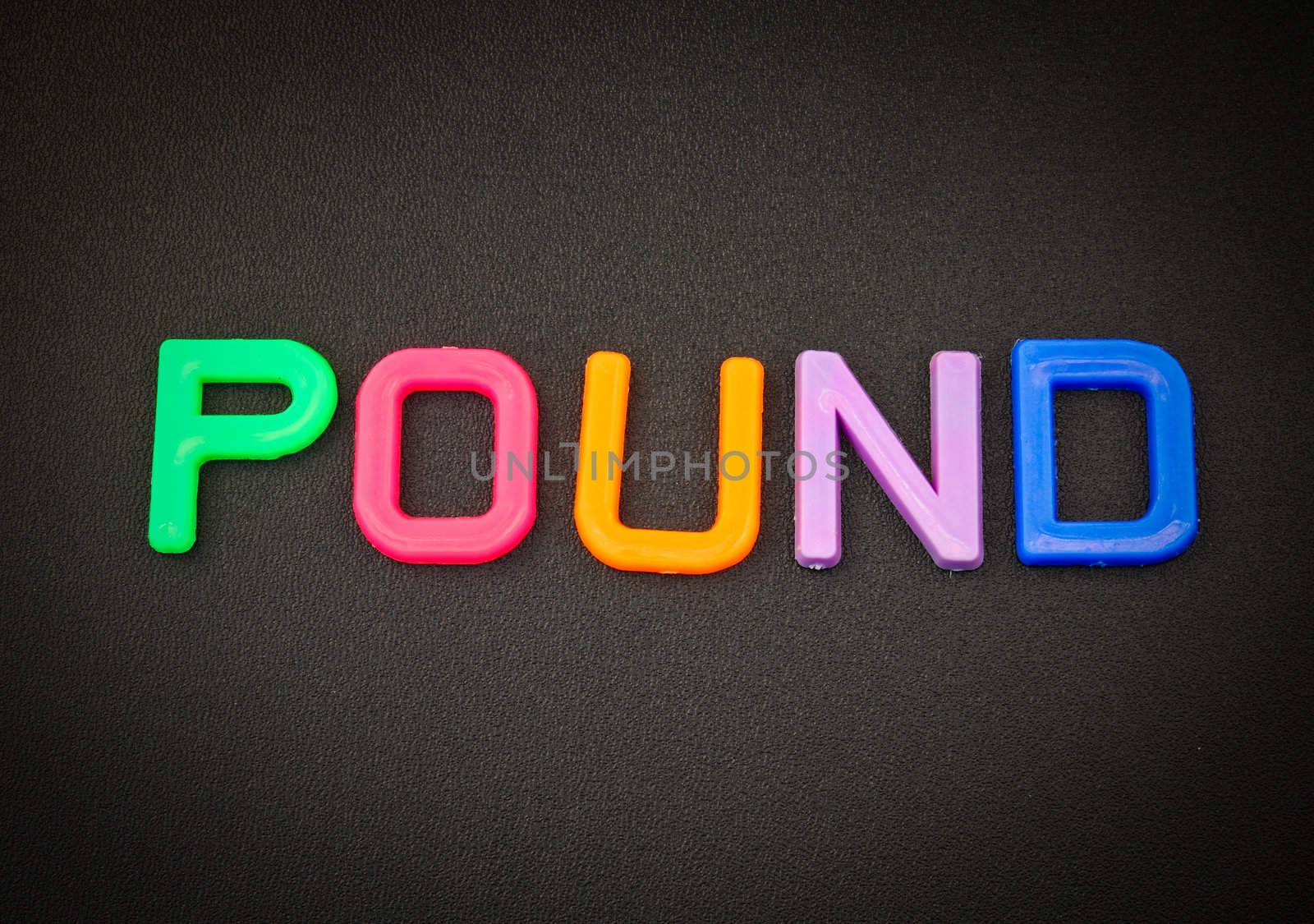 Pound in colorful toy letters on black background