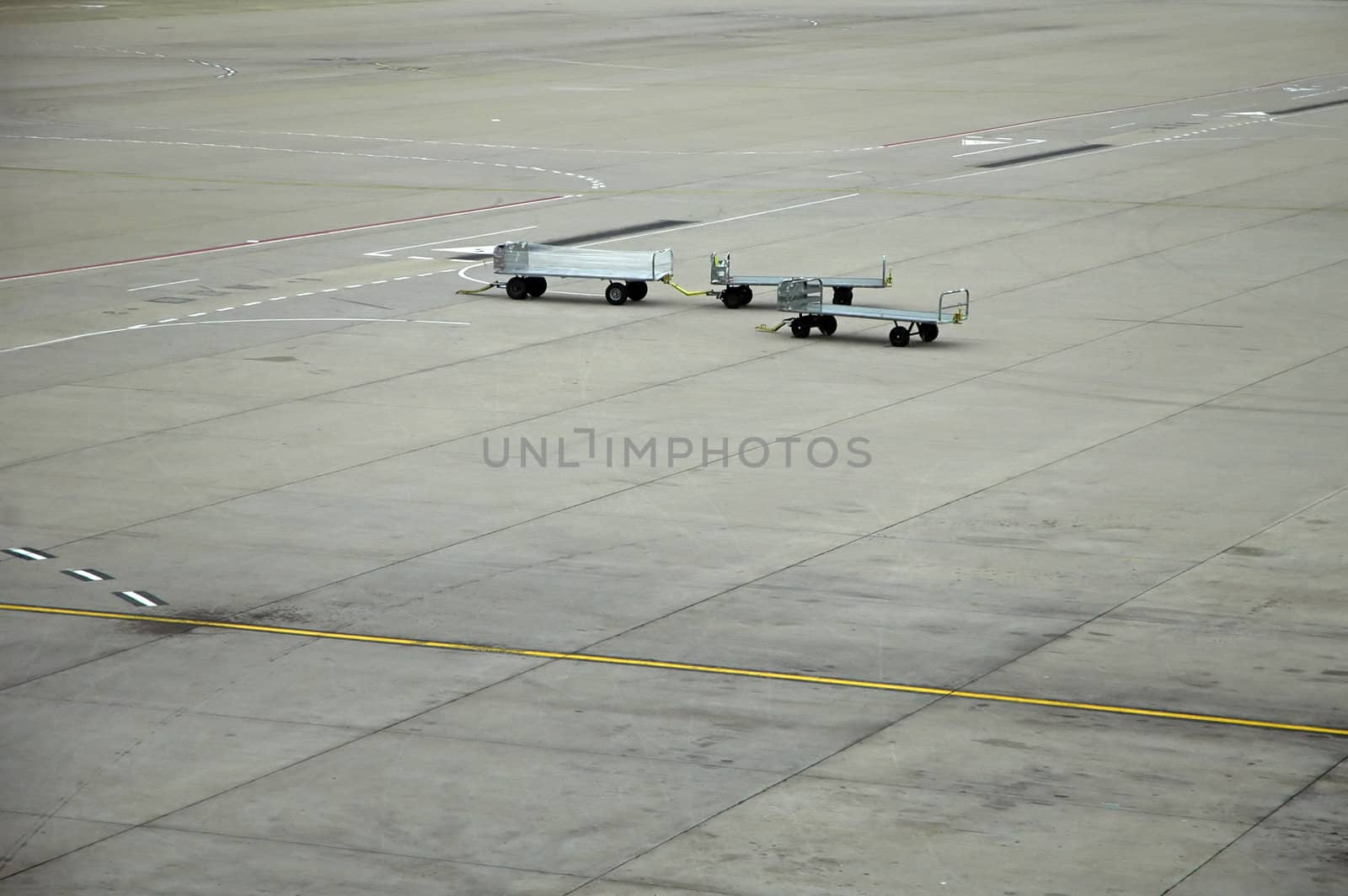 airport scene, three luggage trolleys, grey concrete