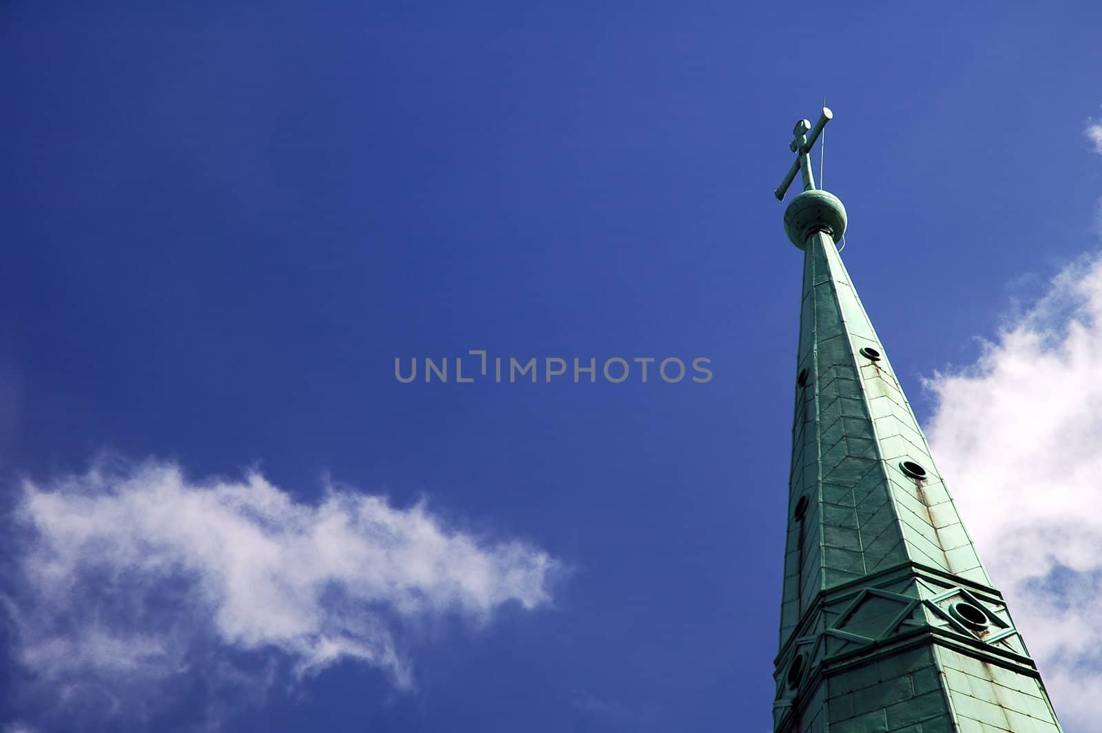 detail photo of copper church roof, cross, blue sky