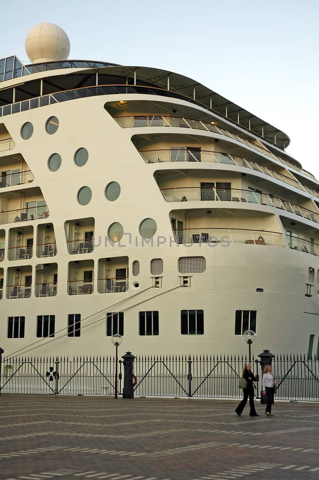 big white passenger boat detail, two persons in front - blurred, harbour location