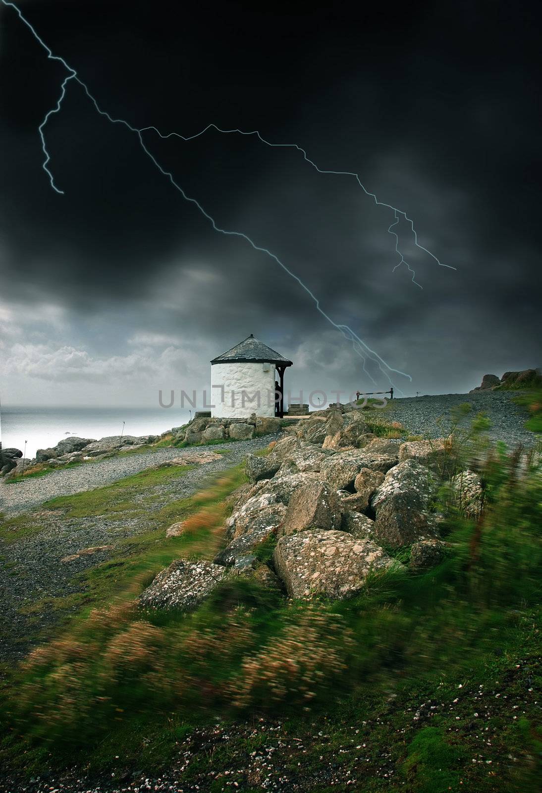 Lightning strike and strong wind blowing by the ocean in Land's End, UK