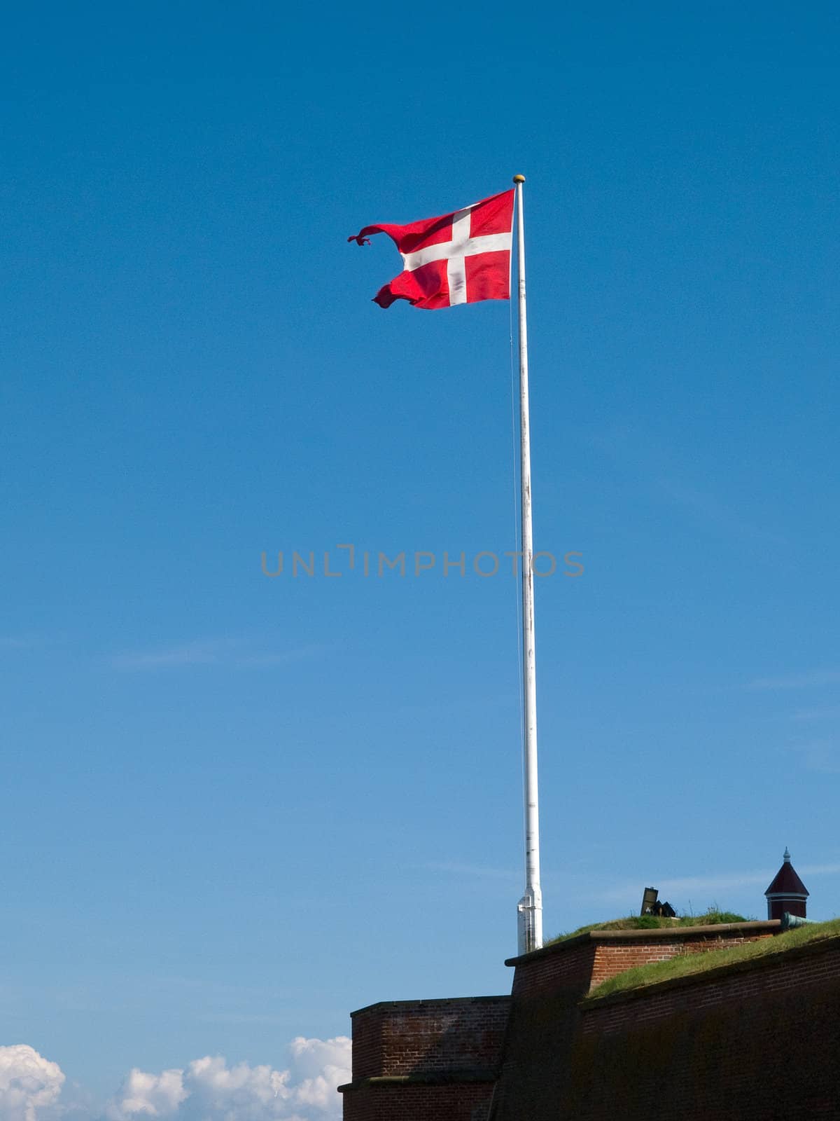 Flag of Denmark up high in the air with blue sky background