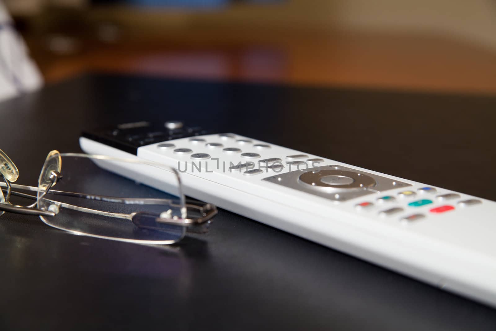 TV remote controller and glasses on the table
