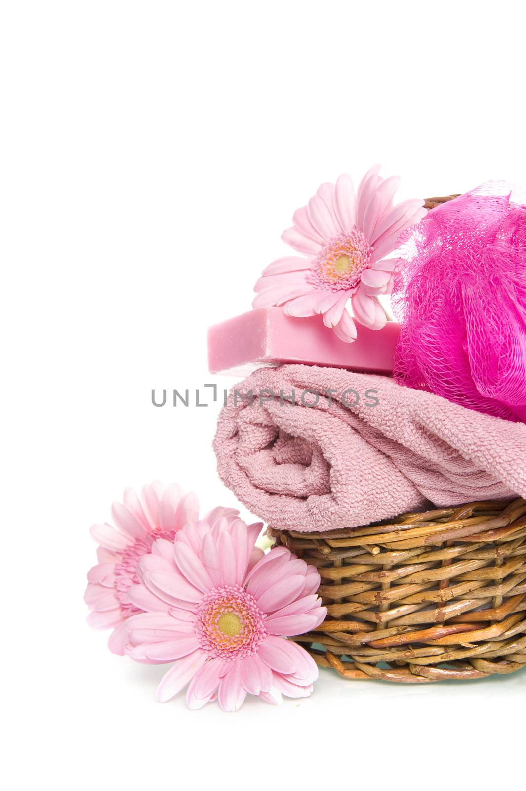 a towel, a sponge, soap and a flower in a basket