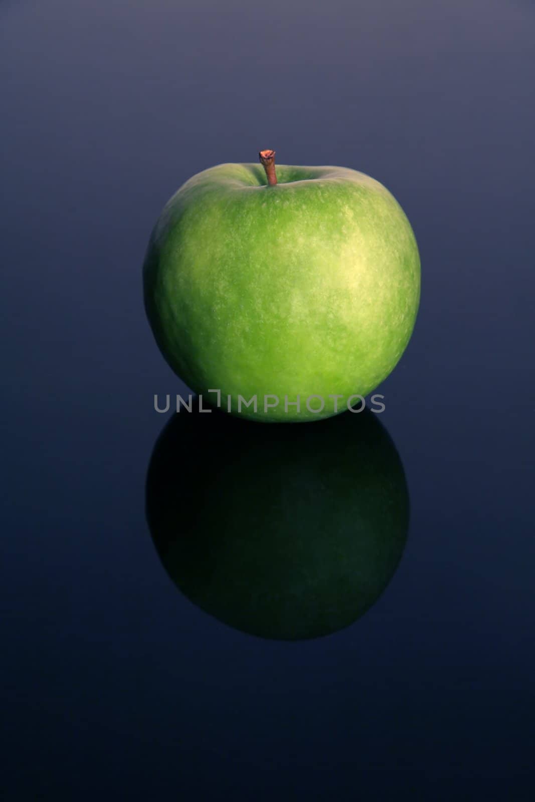 green isolated apple on blue reflective background, 