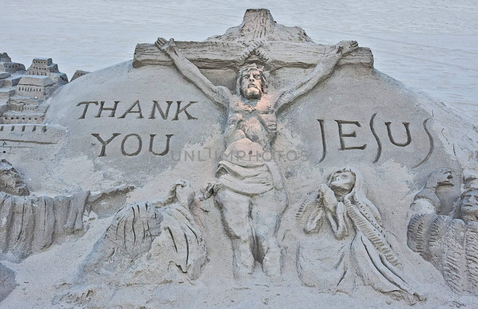 A sand sculpture on a beach of the crucifixion of Jesus