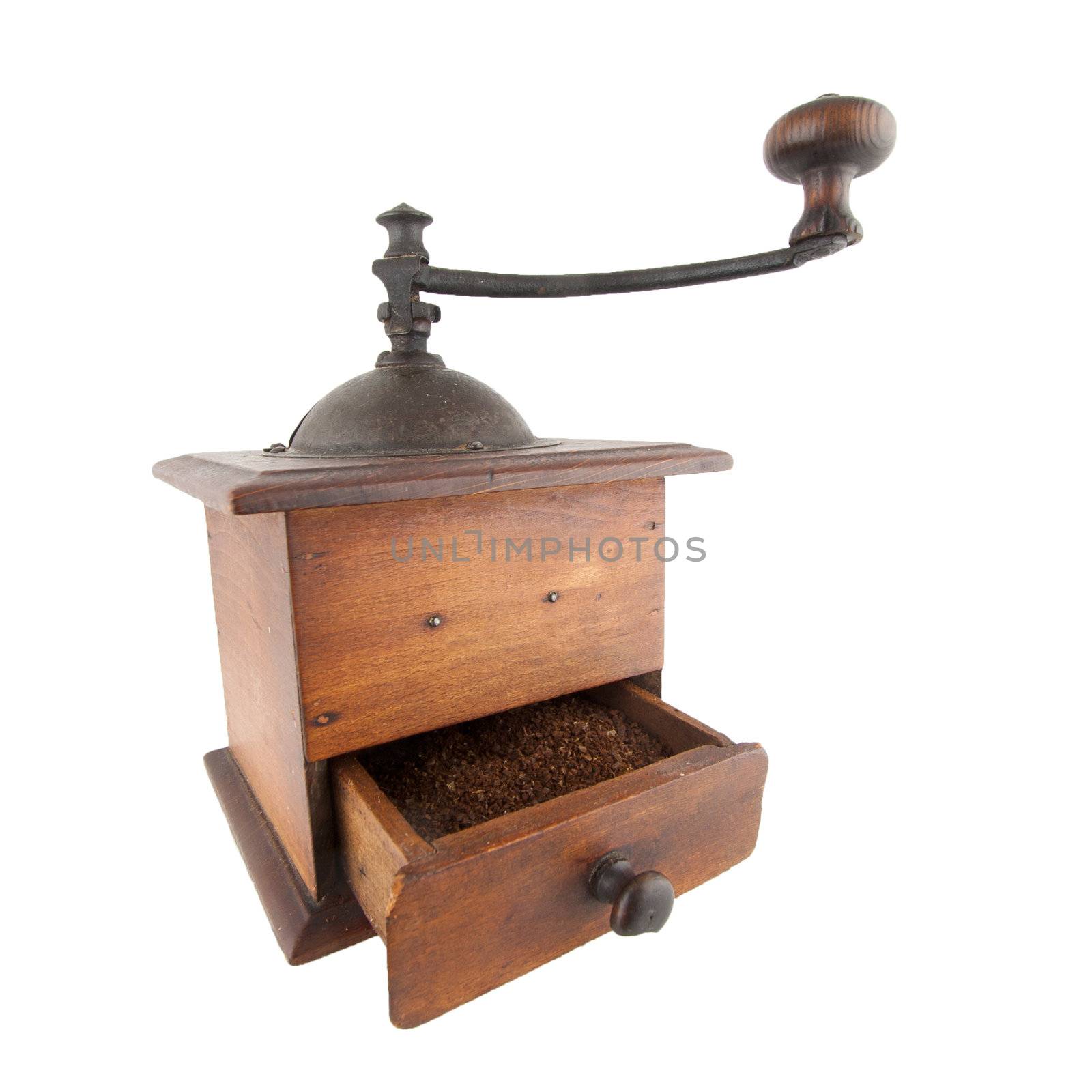 Old coffee grinder with ground coffee in the drawer