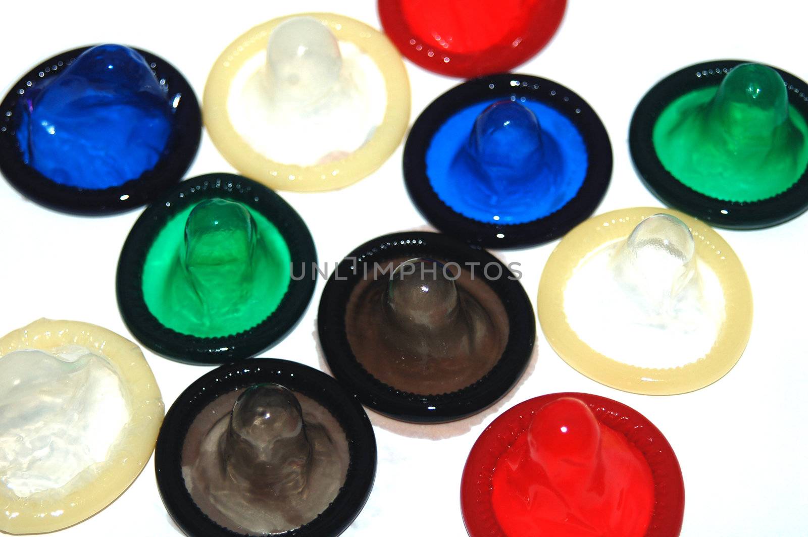 Assortment of brightly coloured condoms on white background
