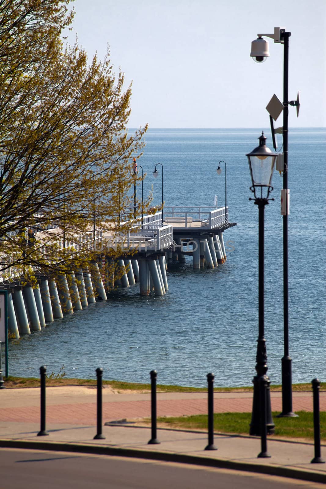 Wooden pier and lantern on the sea coast
