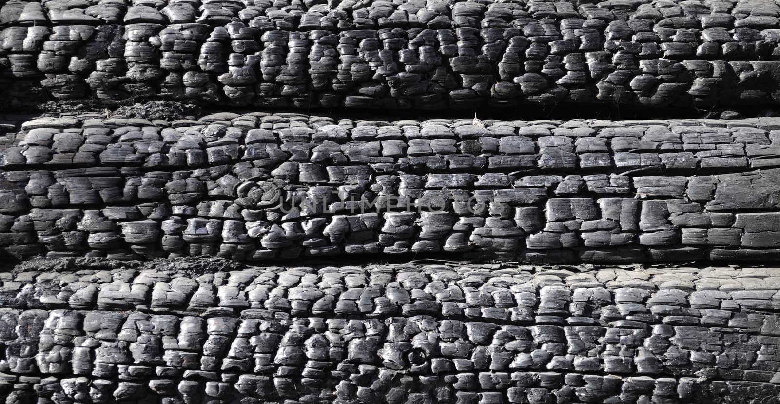 Close up of black burnt log wall background