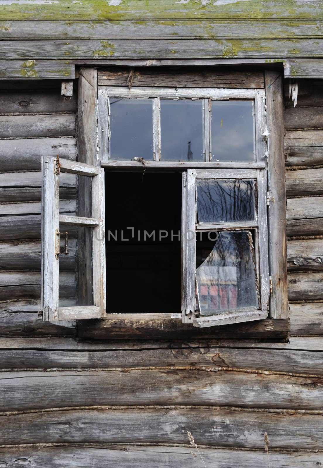 Broken window on old abandonned wood house