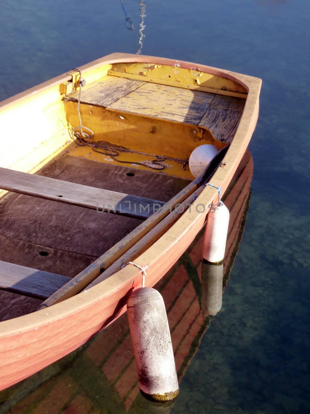 Close up of an old small red boat floating on the water