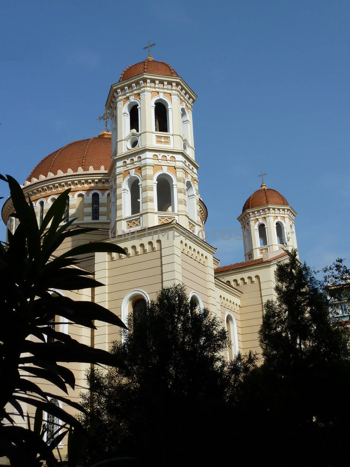 Tower of the Metropolitan Church of Thessaloniki, Greece, behind the shadow of several plants and trees