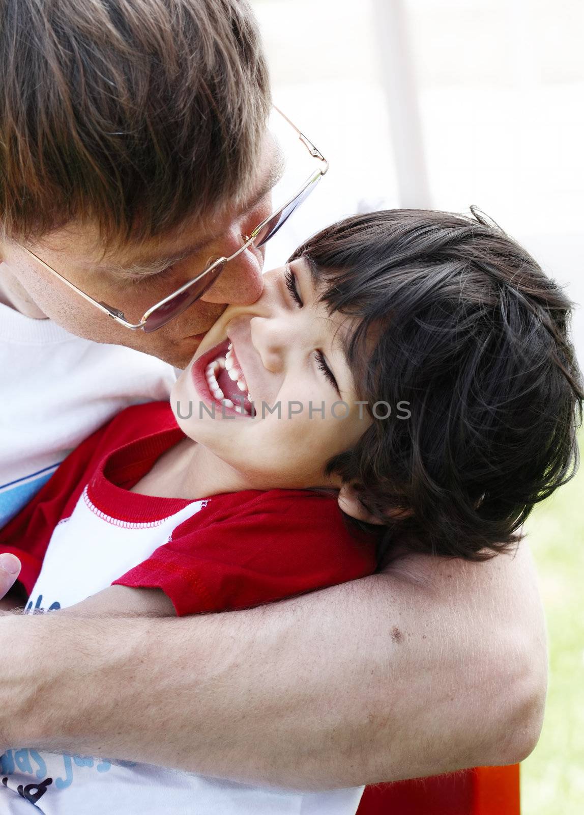 Father kissing his son, three years old