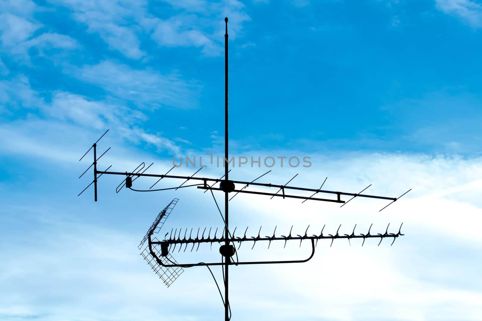 old analog television antenna against blue sky by artush