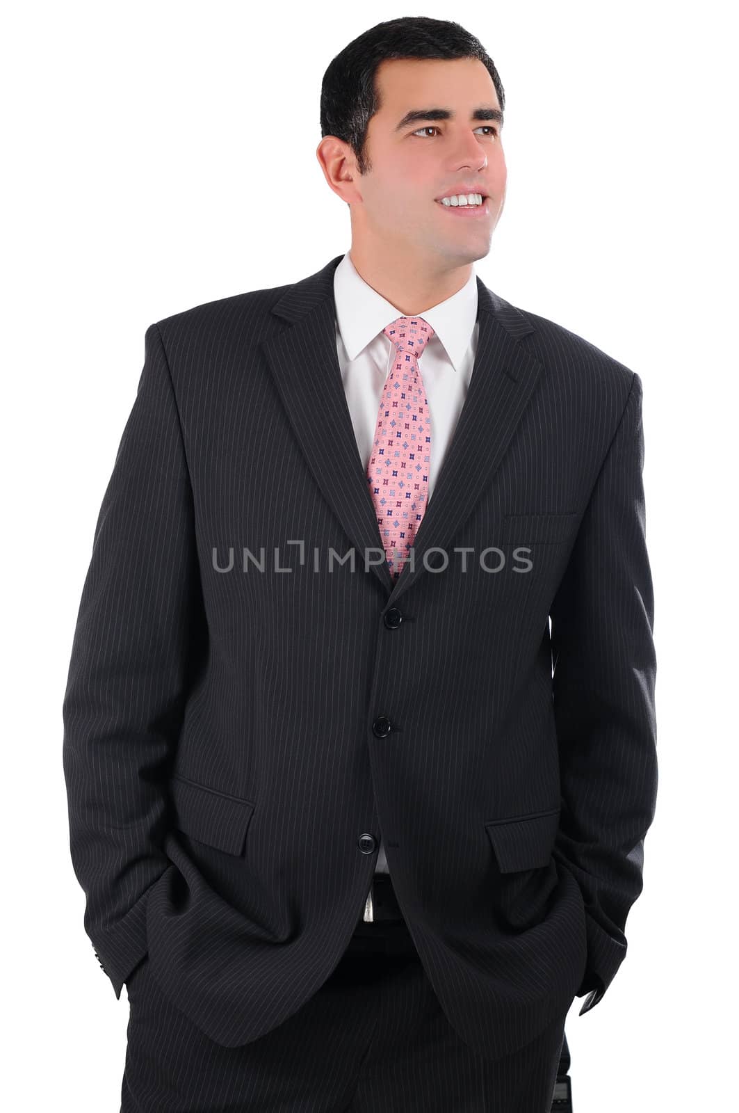 Portrait of a young smiling businessman in a dark suit with hands in pockets by gravityimaging1