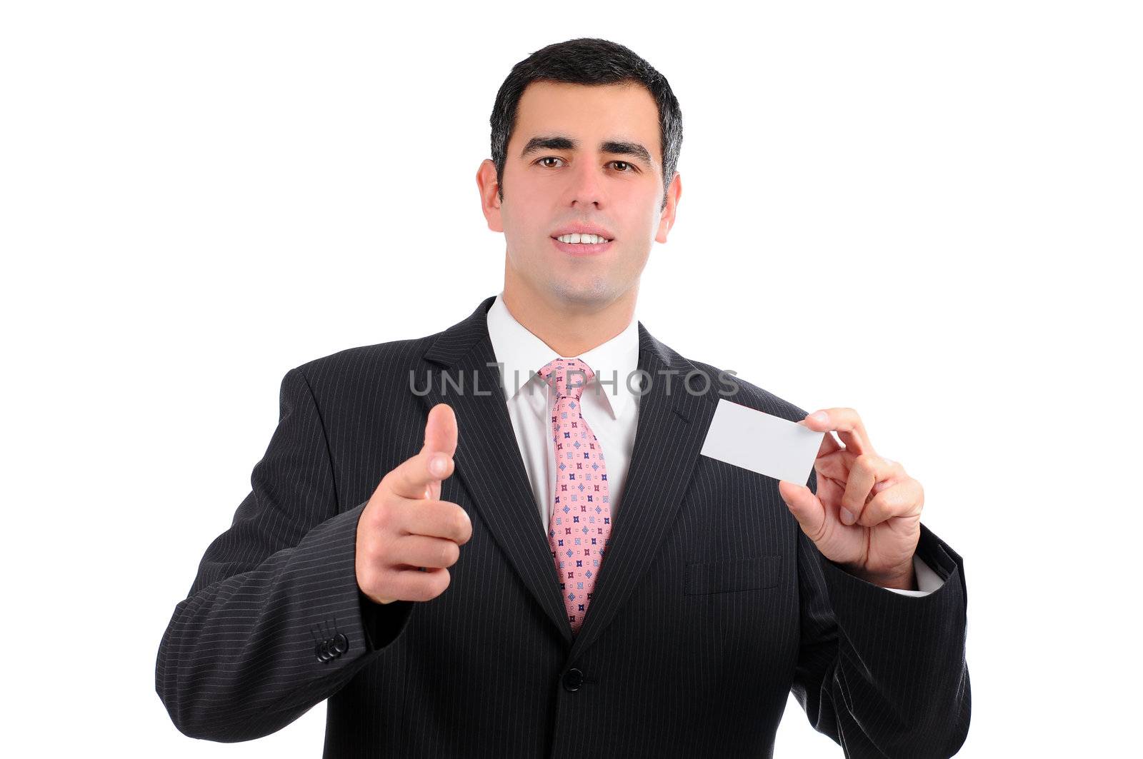 A cheerful businessman in a dark suit pointing forward with a business card in right hand