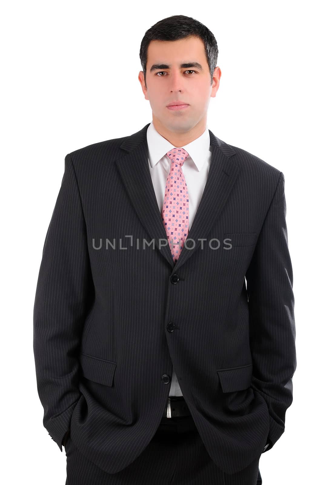 Portrait of a businessman in a dark suit with hands in pockets by gravityimaging1