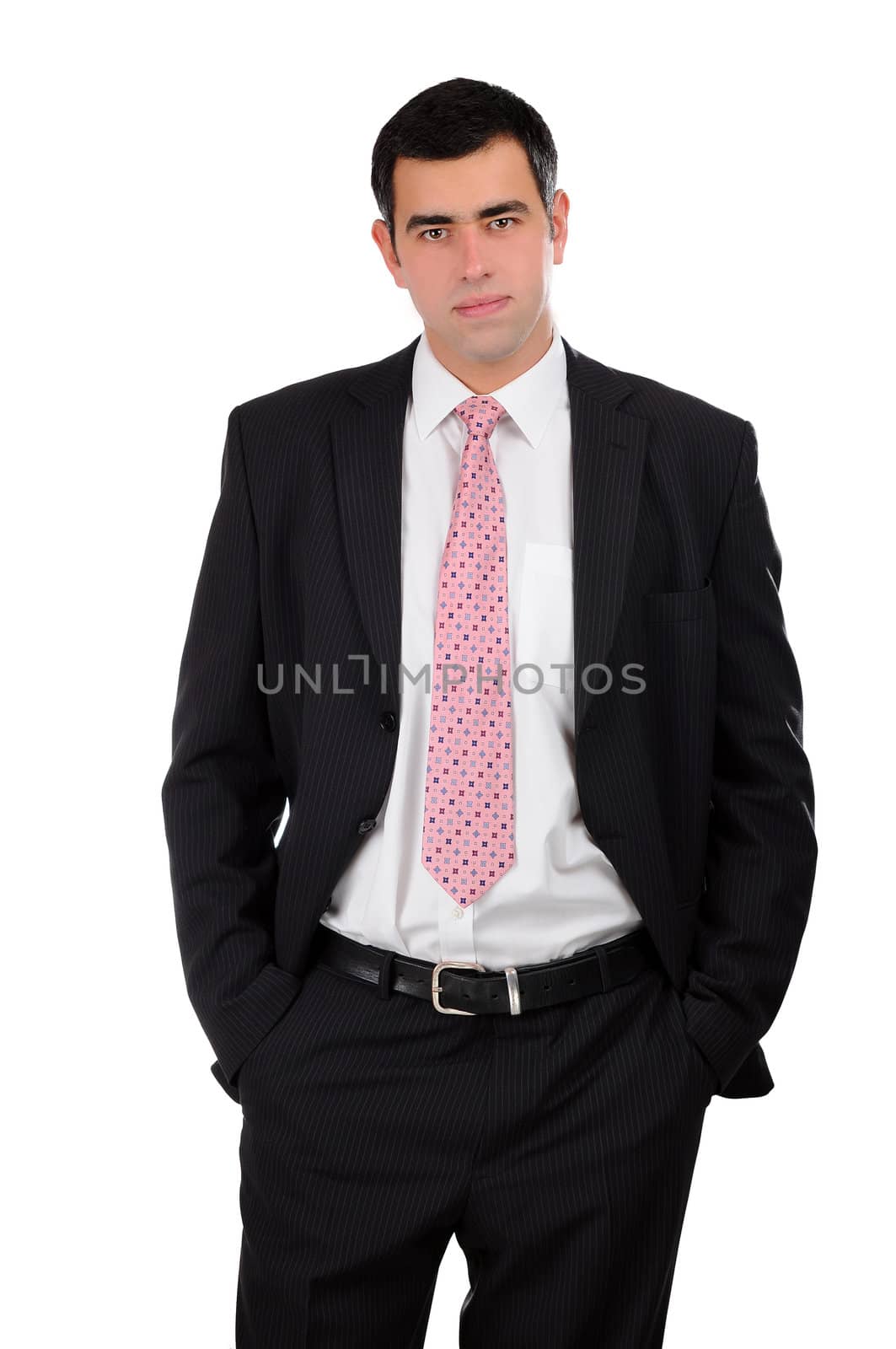 Portrait of a young businessman in a dark open suit with hands in pockets by gravityimaging1