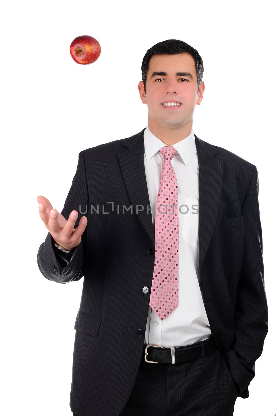 Portrait of a young smiling businessman tossing an apple by gravityimaging1