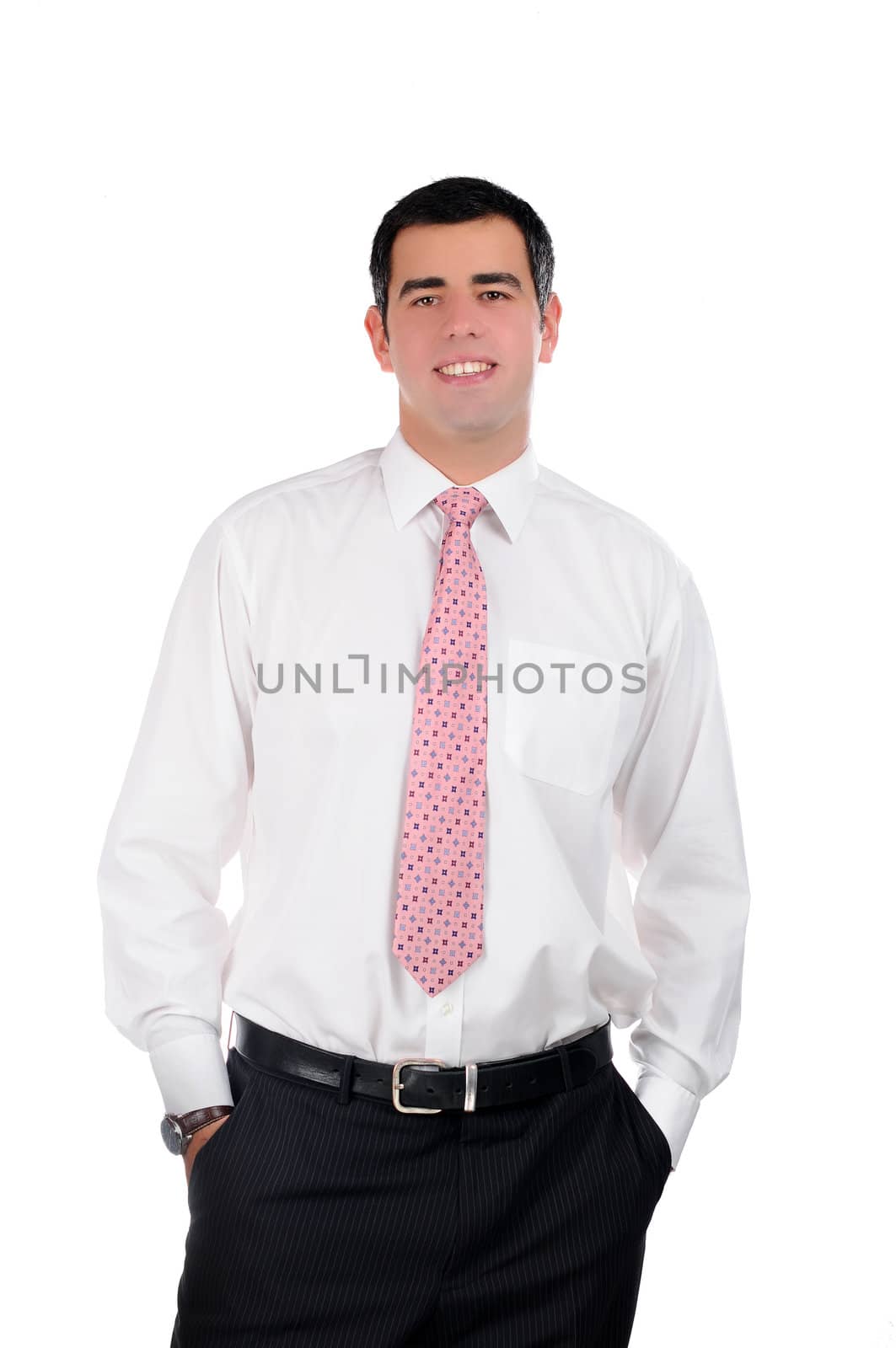 Portrait of a young smiling businessman in a white shirt with hands in pockets