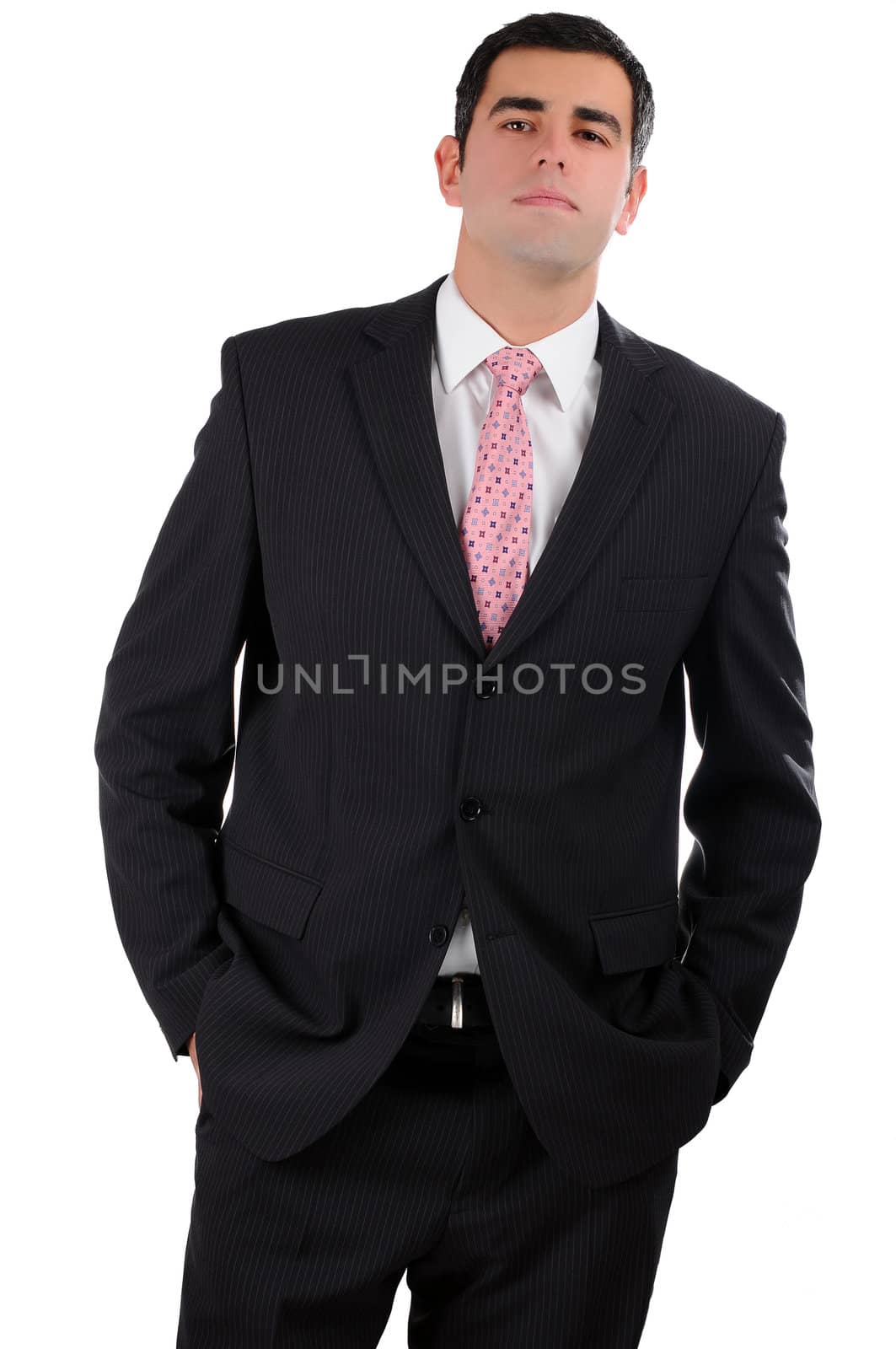 Portrait of a young businessman in a dark suit with hands in pockets by gravityimaging1