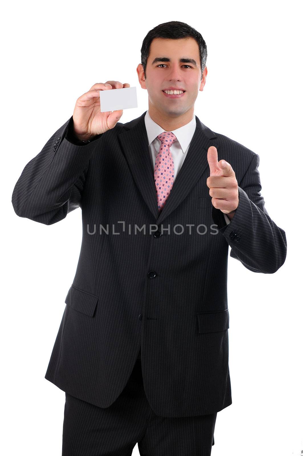 A cheerful businessman in a dark suit pointing forward with a business card in right hand by gravityimaging1