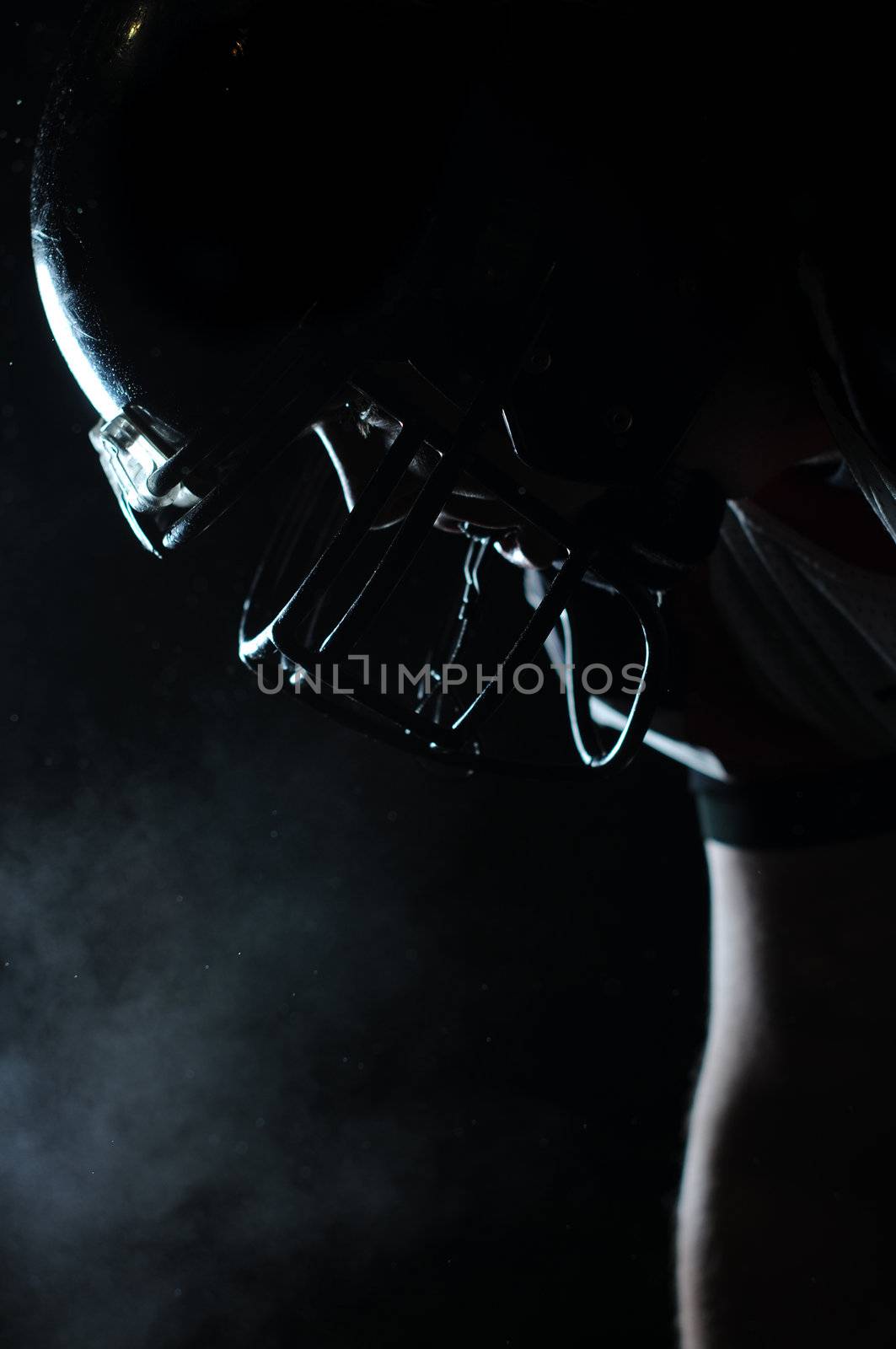 Backlit portrait of american football player in helmet ready to play by gravityimaging1