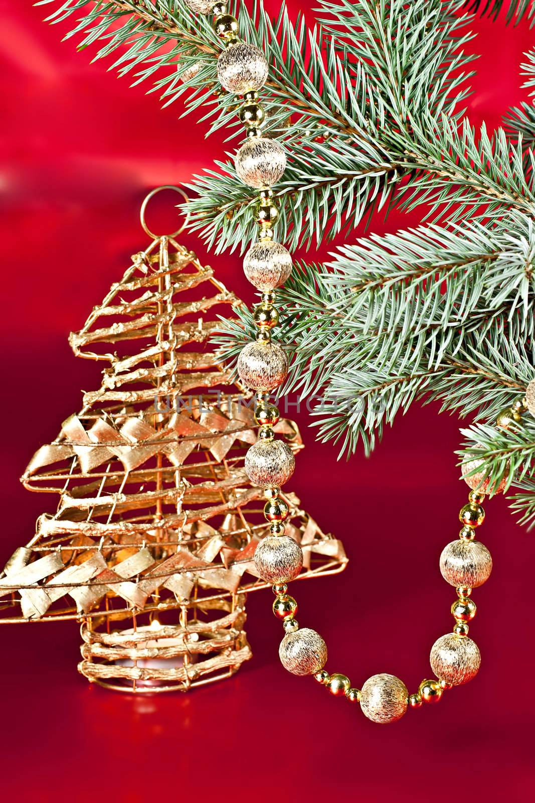 
On a red background with a spruce twig Christmas decoration ball on a string of candlesticks.
