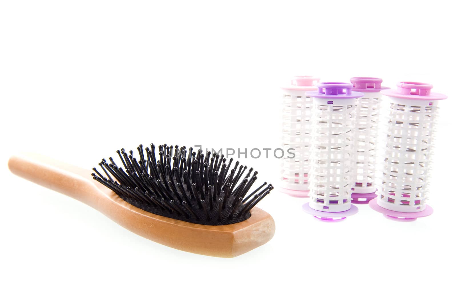 a hairbrush and curlers on a white background