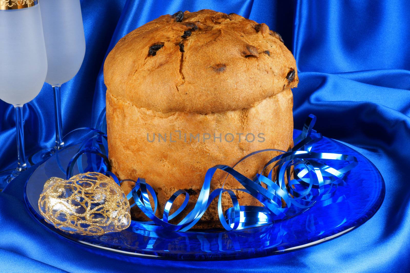 Italian Christmas composition with panettone and spumante over a blue background. Selective focus.