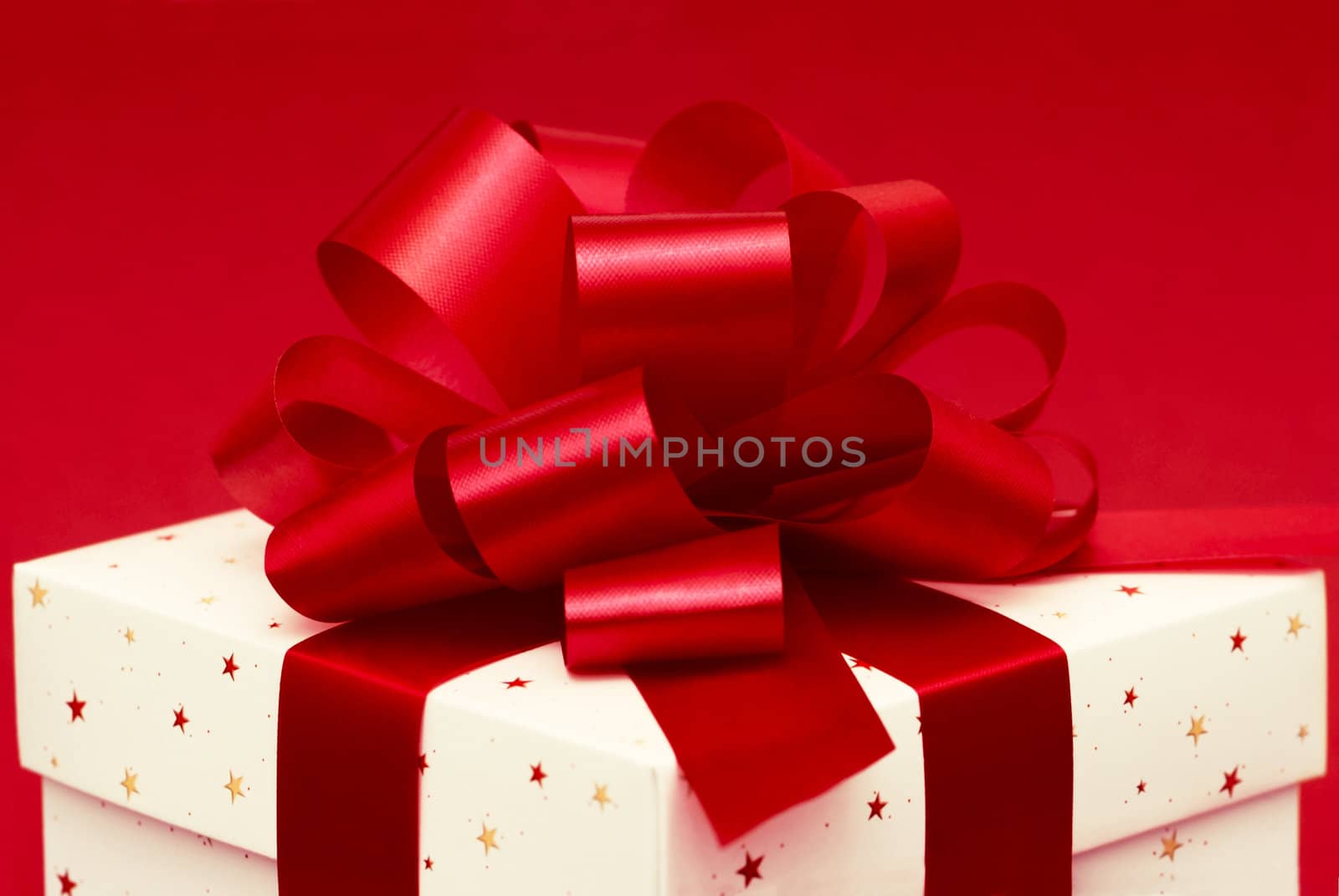 Christmas gift with red ribbon isolated on red