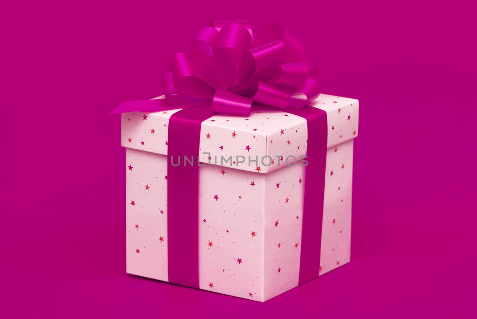 Christmas gift with purple ribbon isolated on red background