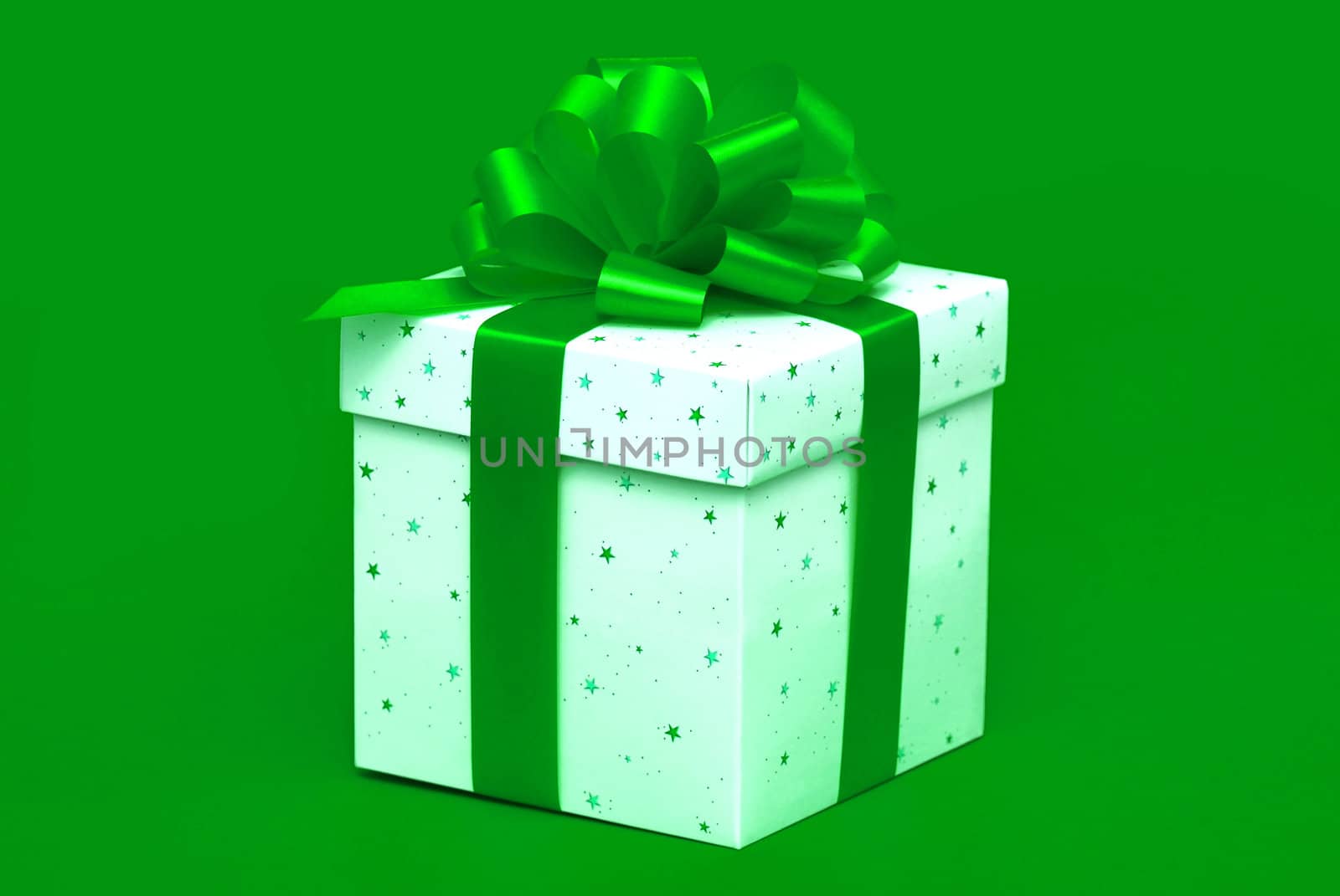 Christmas gift with green ribbon isolated on green background