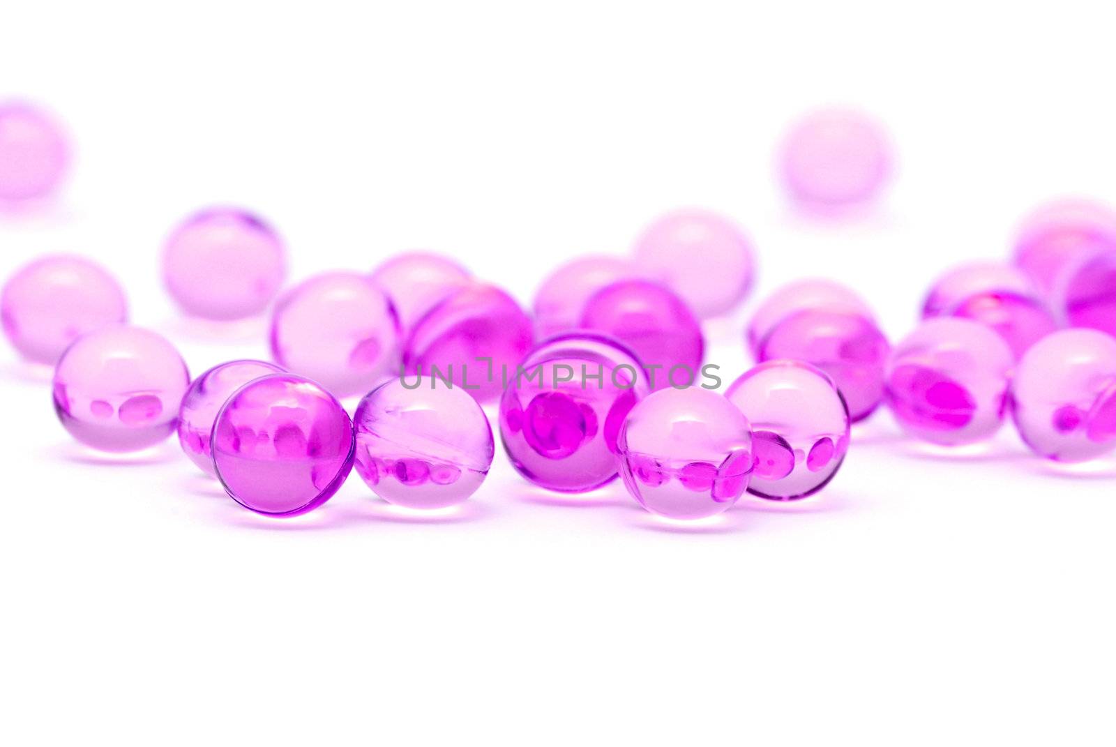 Transparent purple capsules isolated on white