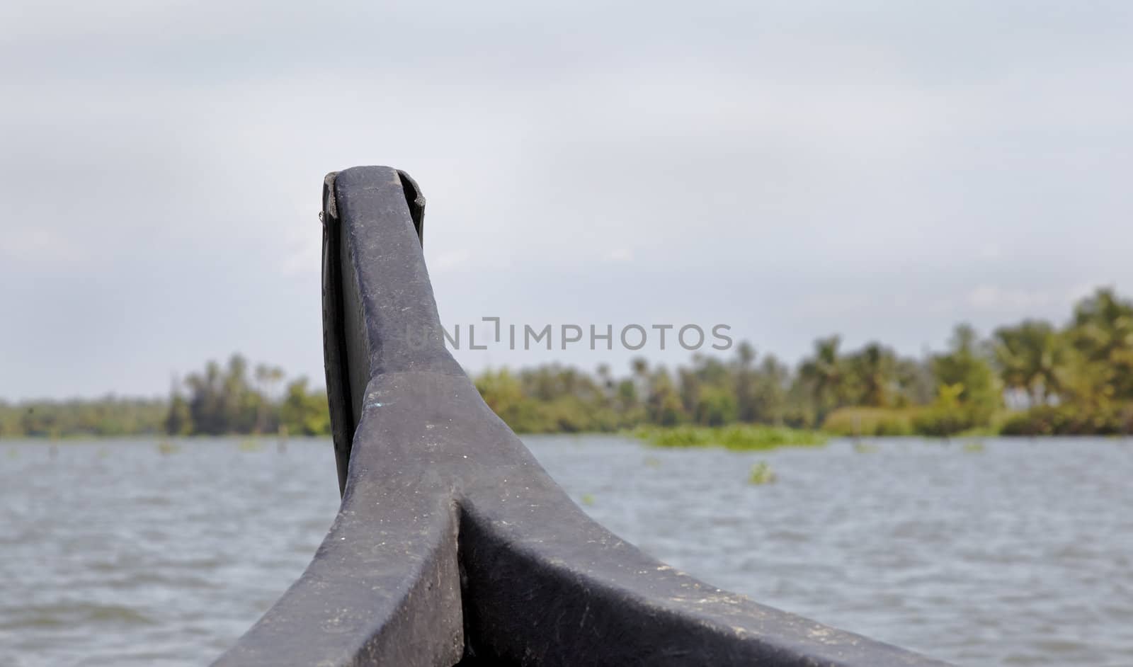 landscape of back waters of Kerala front of sailing boat with land ahead, cloudy sky horizontal scene crop space and copy area